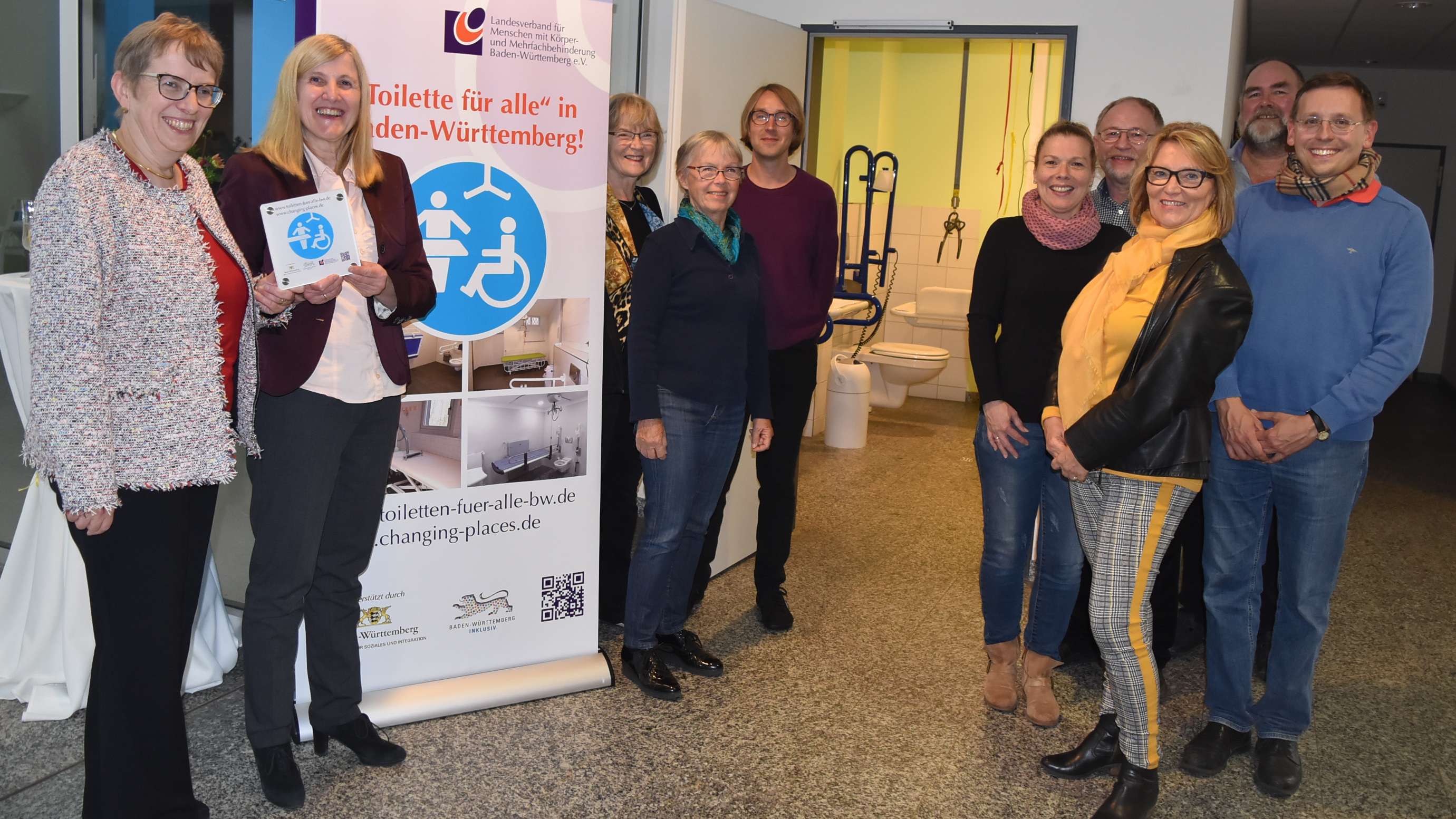  Jutta Pagel-Steidl (Geschäftsführerin LVKM) überreicht Bürgermeisterin Claudia Felden ein Hinweisschild für die "Toilette für alle" 